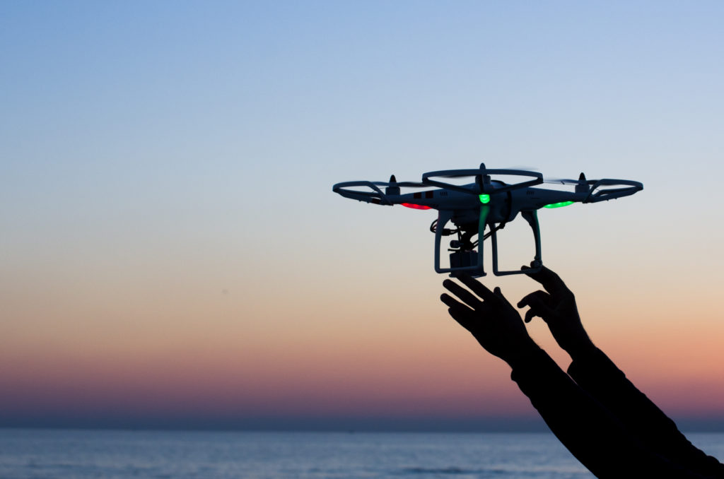 Viareggio, Italy - October 30, 2014: Drone takes off from the operators hand with camera at sunset Quadcopter industry is told to be growing at triple digitsevery year, for a market expected to pass the 20 billion in the 2020. The dji is a chinese company leader of quadcopter industry, and the phantom is expected to be the top seller gift for christmas 2015