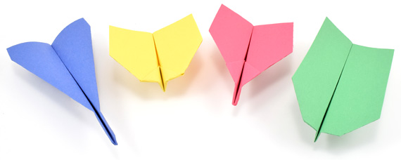 4 different types of paper airplanes, one blue, yellow, pink, and green.
