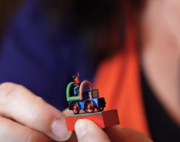 Person holding a very small toy car