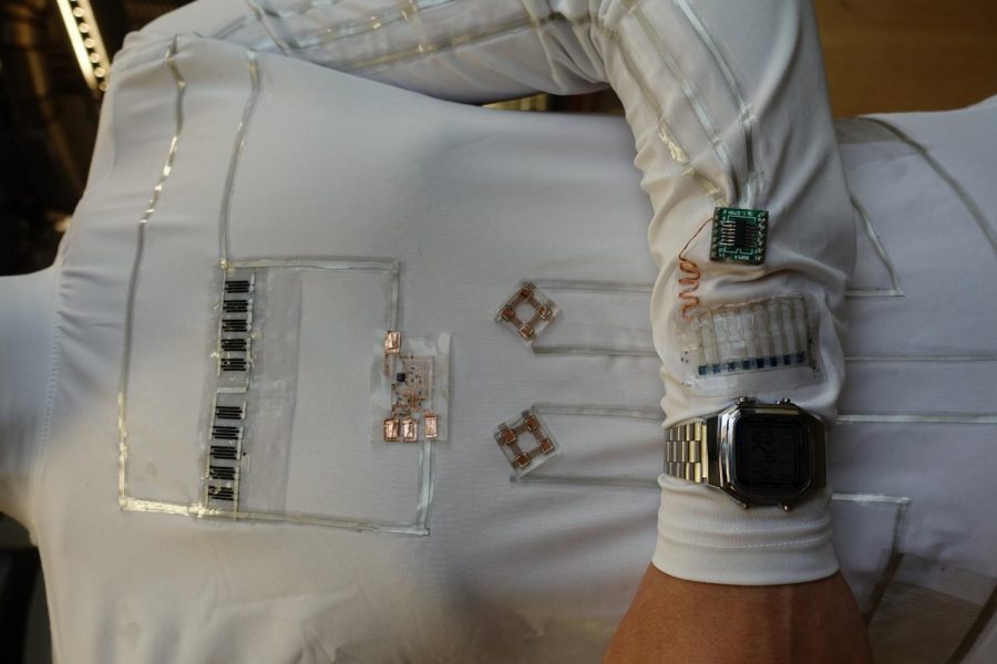 The wearable microgrid uses energy from human sweat and movement to power an LCD wristwatch and electrochromic device. Credit: Lu Yin
