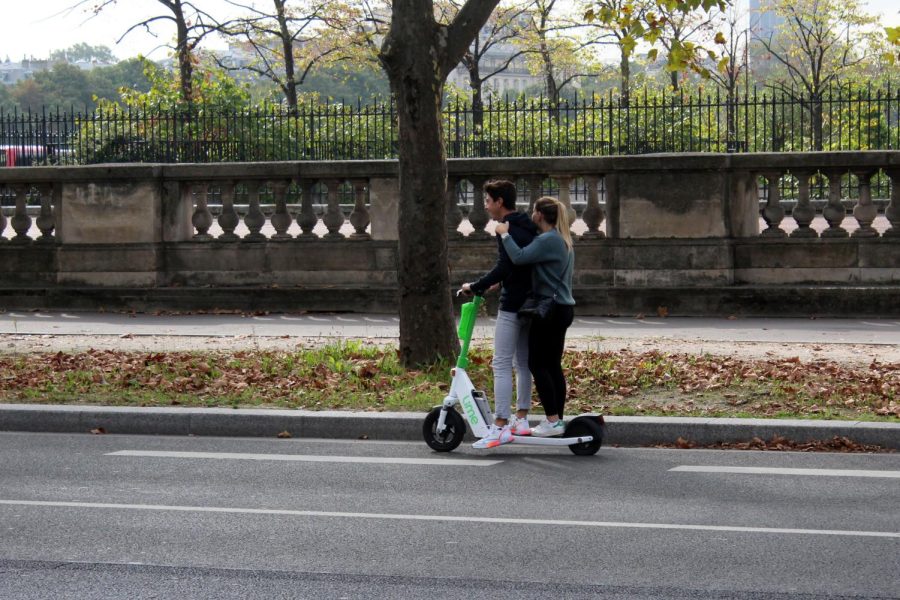 Two people riding a Lime electric scooter in France.