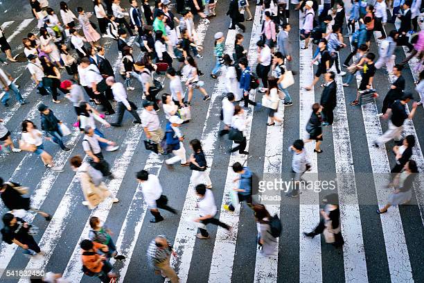 Many people cross the street on a zebra crossing in the Osaka