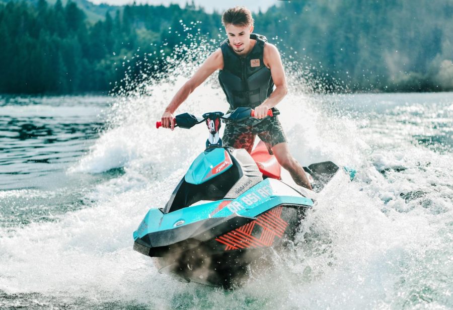 photography of man riding personal watercraft during daytime