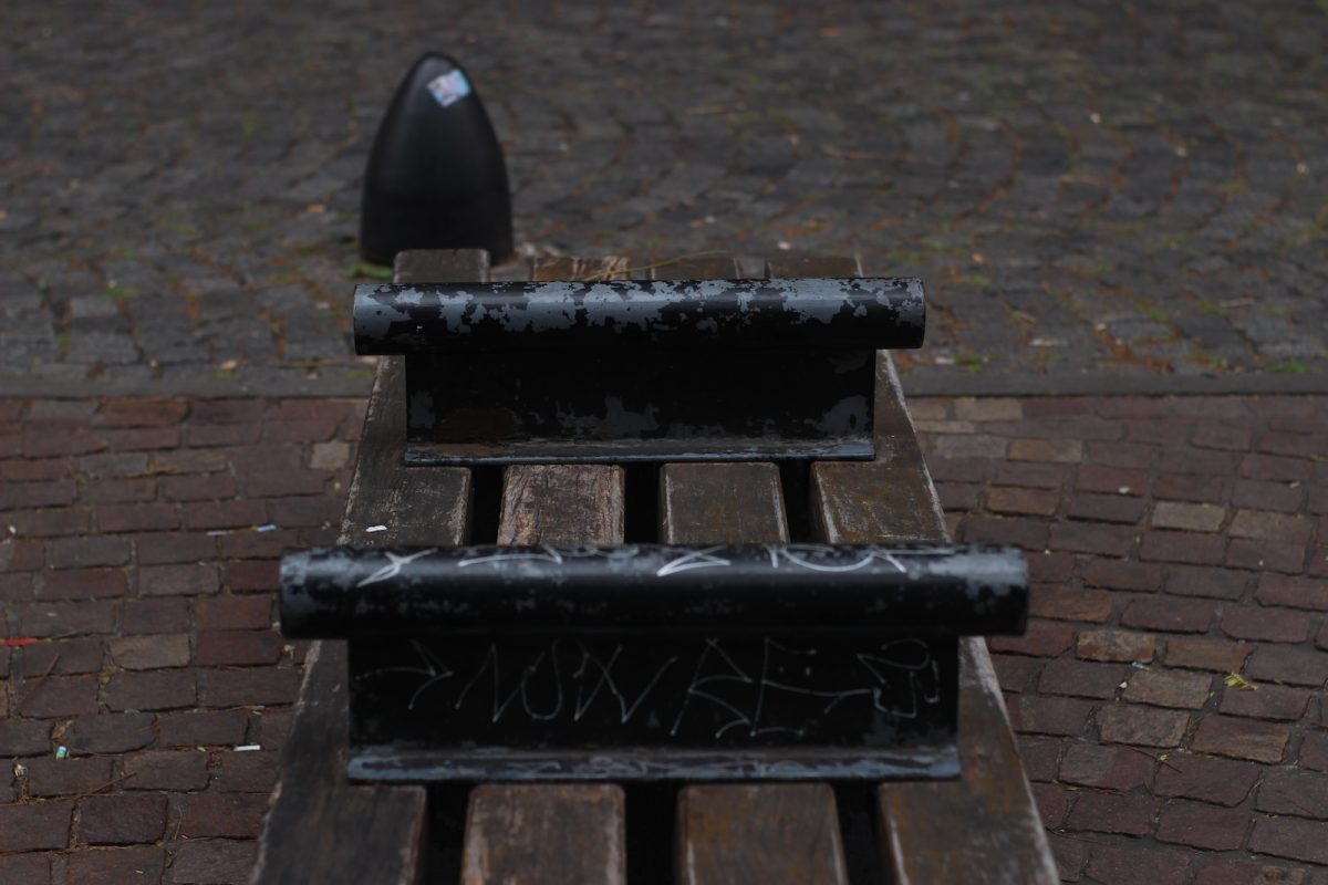 a wooden bench with graffiti written on it