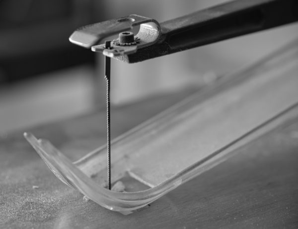 a pair of pliers cutting a piece of glass