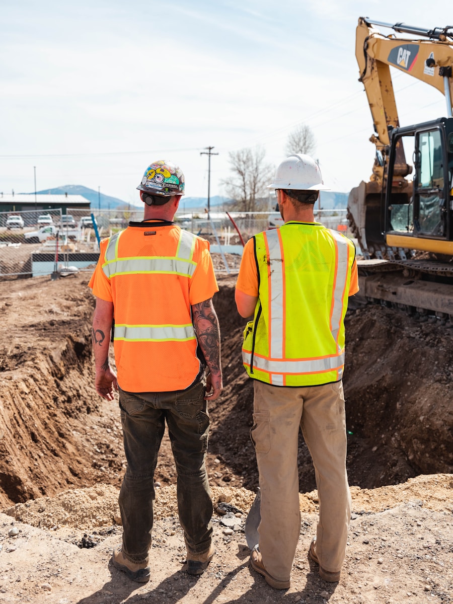 men in safety vests standing in front of a construction vehicle