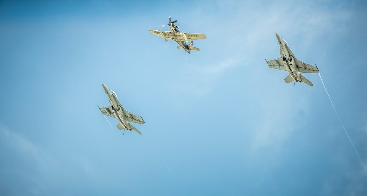 three gray-and-black jet planes under clouds