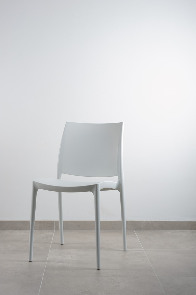 white armless chair near white wall